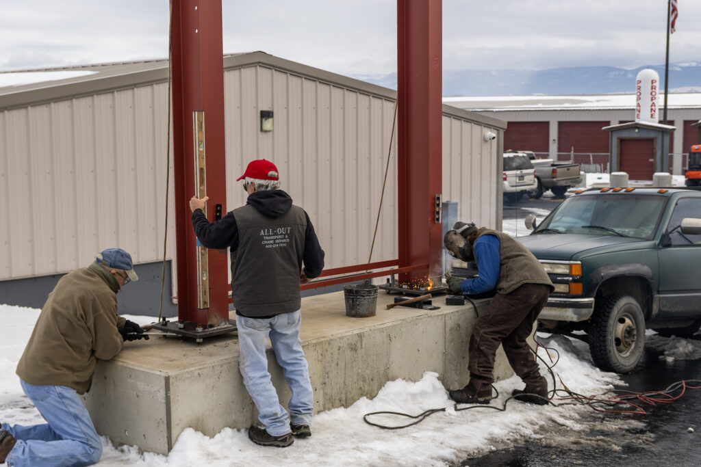 Checking for any final adjustments and tightening mounting bolts as the welding process continues.